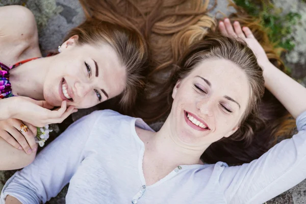 Closeup portrait of lying head to head happy girl friends relaxing happy smiling