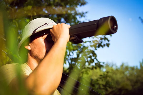 Exploring scientist observing romantic male in pith helmet having fun looking in magnification scope on summer sunny day green woods & blue sky outdoors copy space background portrait picture