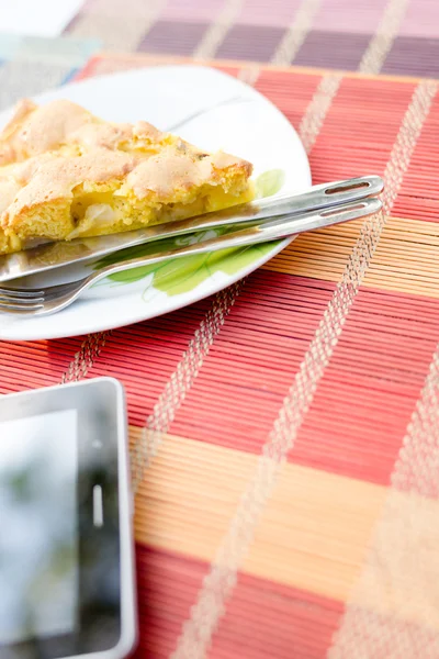Piece of  biscuit apple pie and tablet pc
