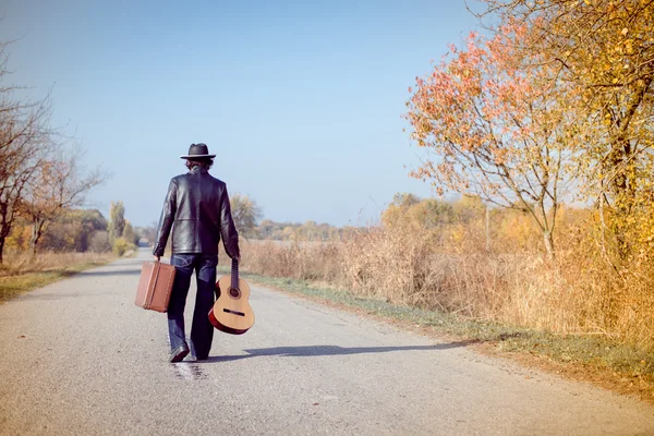 Man with suitcase and guitar