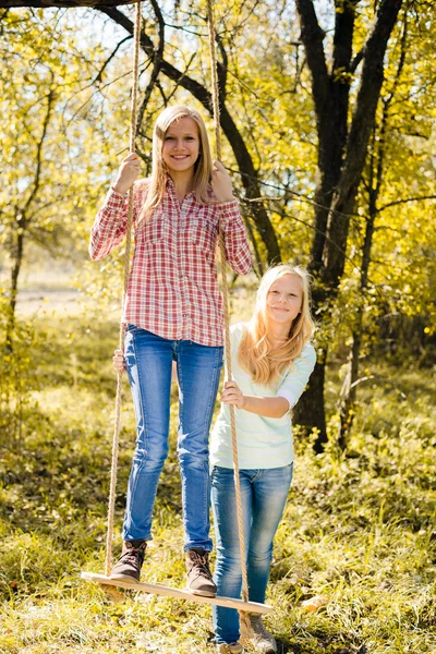 Girls sitting on swing