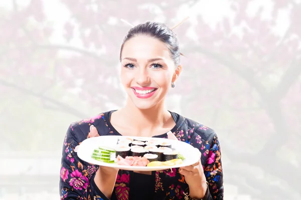 Woman holding a plate of sushi