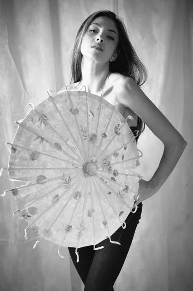 Black and white image of beautiful woman holding asian umbrella