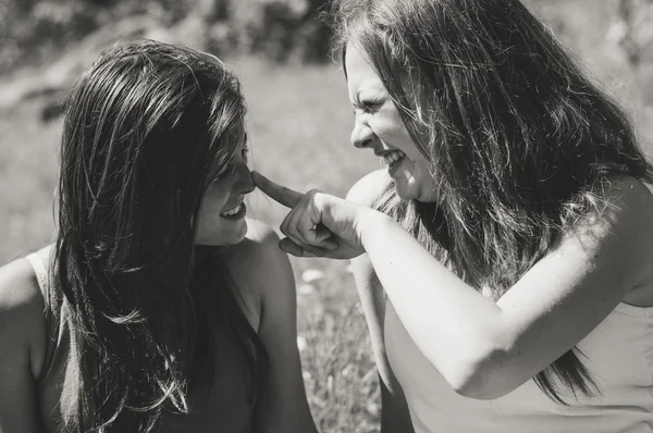 Happy girl friends playing in grass. Black and white picture