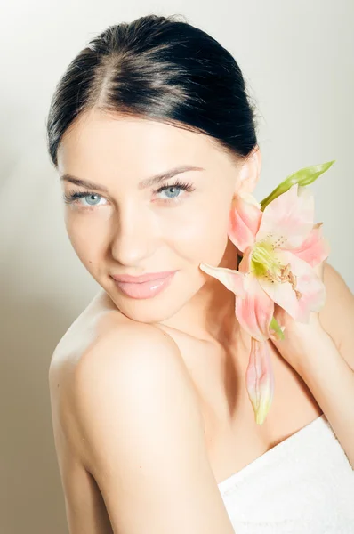 Beautiful lady with lilly flower. Perfect skin.