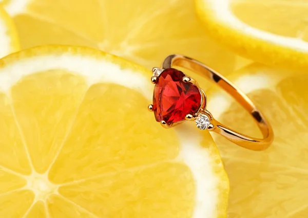 Jewellery ring with big gems on lemon background, horizontal com