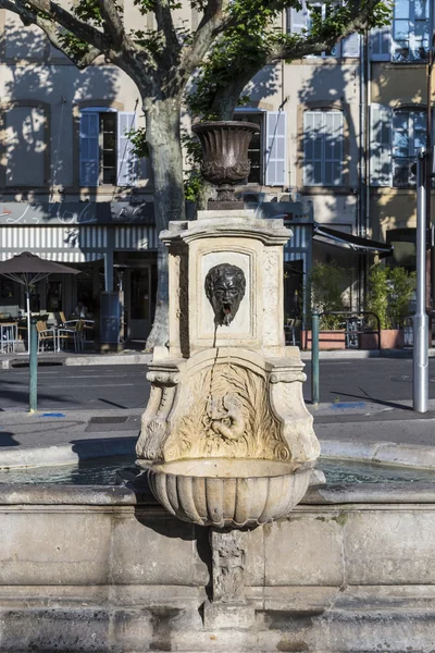Old water fountain with greek roman face at faucet