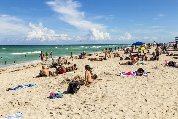 People enjoy the hot summer day at south beach in Miami