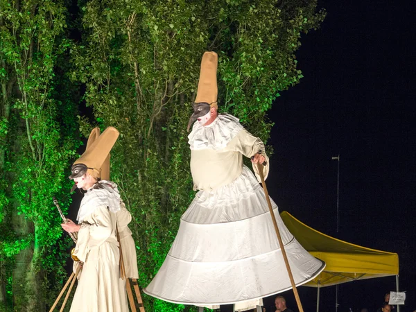 People on stilts perform Romeo and Juliet  wearing carnival cost