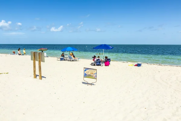 People relax at the Crandon Park beach