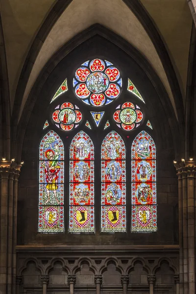 Beautiful windows of the minster show religious scenes from the