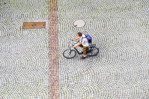 Man crosses the market square at the cathedral with his bike