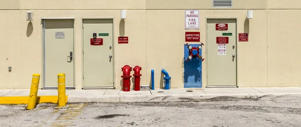 Fire hydrant and emergency exit at a backwards wall