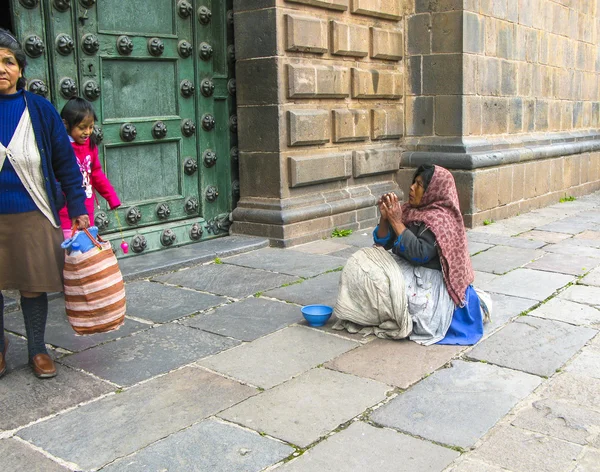 Poor people beg for an alm in front of the basilica de la cathed