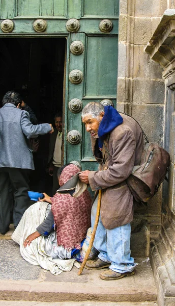 Homeless indian woman begs for money in front of the church  in