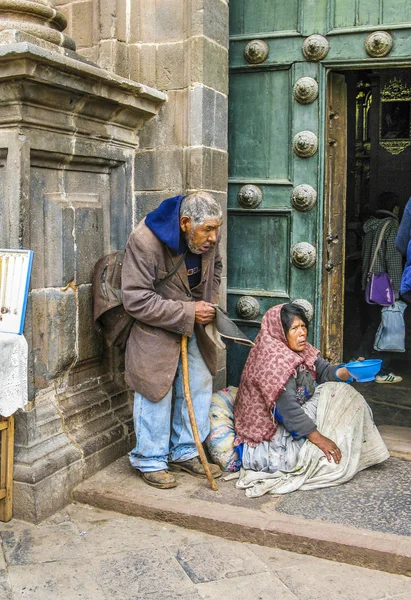 Homeless indian woman begs for money in front of the church  in