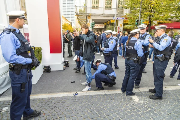 Demonstrant is checked by police at 25th anniversary of German U