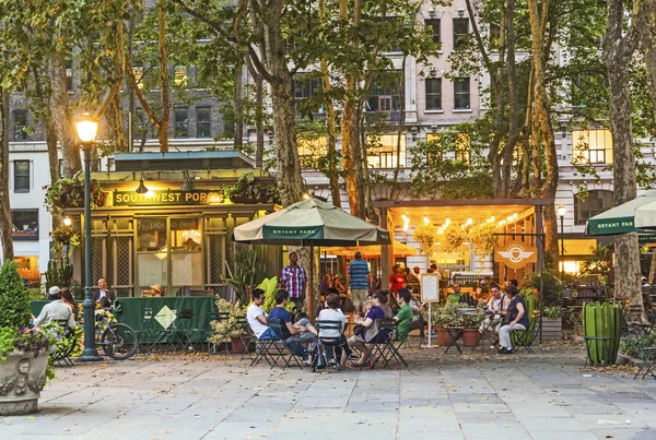 People enjoy the evening at Bryant Park in New York