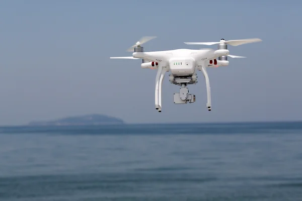 Drone quad copter with flying in the clear blue sky