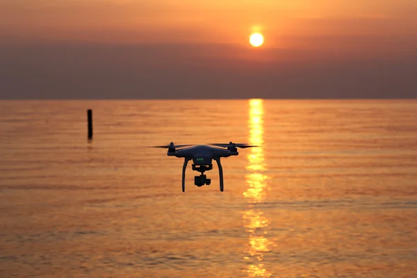 Drone flying against a sunset sky