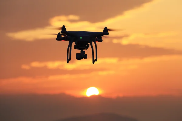 Drone flying against a sunset sky