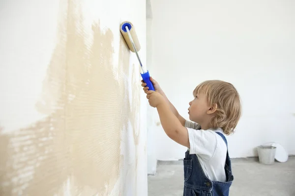 Boy paints the wall roller