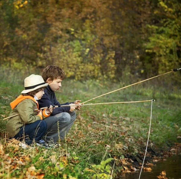 Happy boys go fishing on river