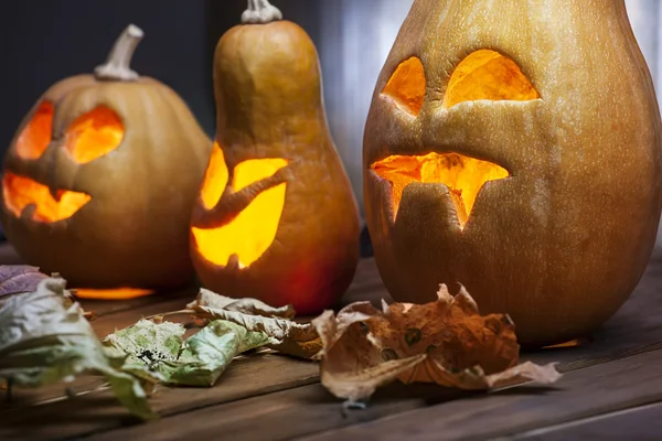 Jack o lanterns Halloween pumpkin face on wooden background