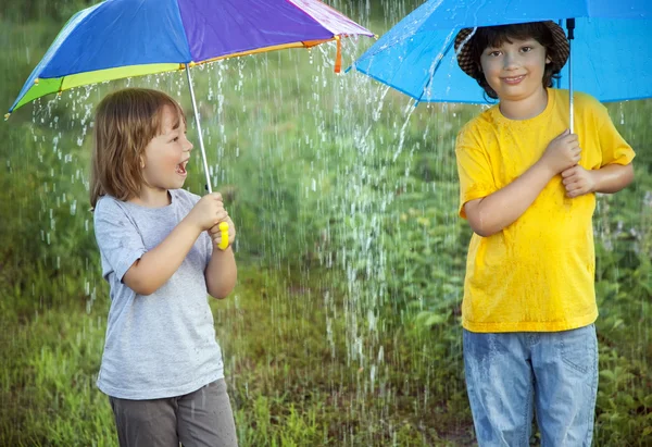 Happy brothers with umbrella outdoors