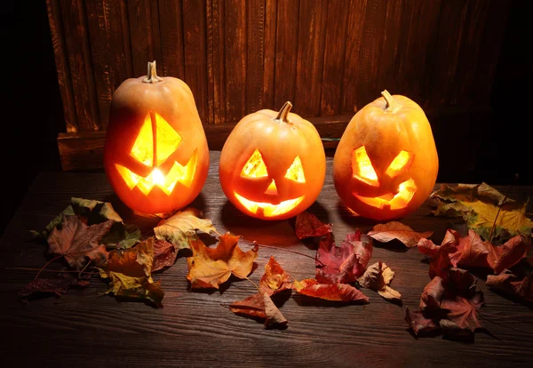 Jack o lanterns  Halloween pumpkin face on wooden background