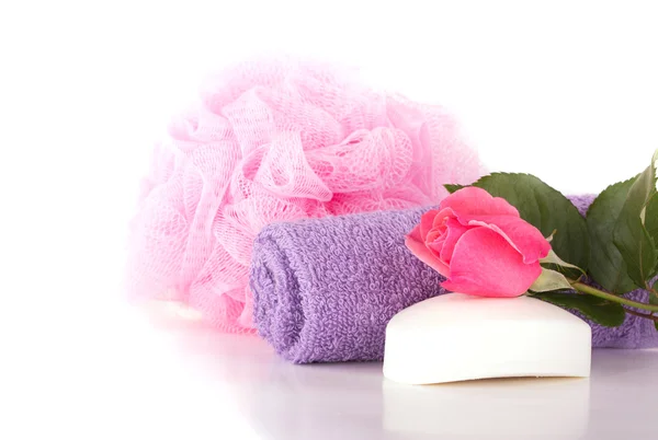 Wash cloth, shower puff, soap and pink rose on light background