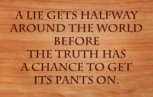 A lie gets halfway around the world before the truth has a chance to get its pants on -quote by on wooden red oak background