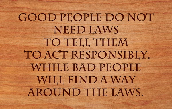 Good people do not need laws to tell them to act responsibly, while bad people will find a way around the laws  - quote wooden red oak background