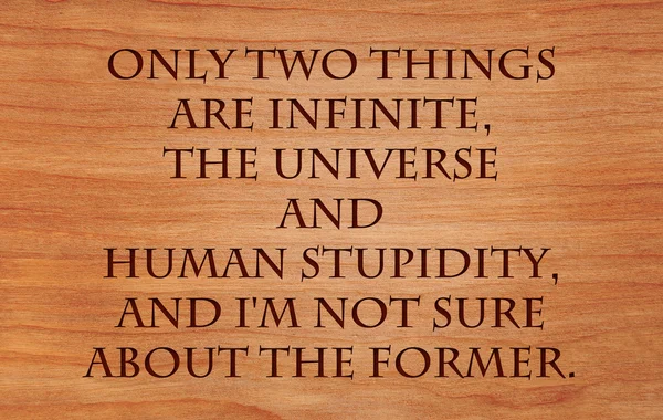 Only two things are infinite, the universe and human stupidity, and I\'m not sure about the former - quote  on wooden red oak background