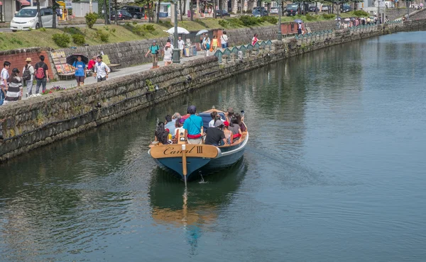 Tourists sightseeing in a tourist boat in Otaru Canals, Japan