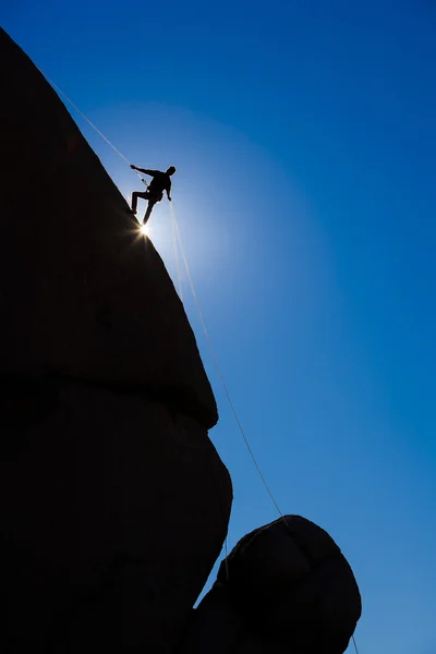 Rock climber rappelling.