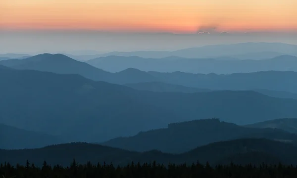 Distant mountain range and thin layer of clouds on the valleys