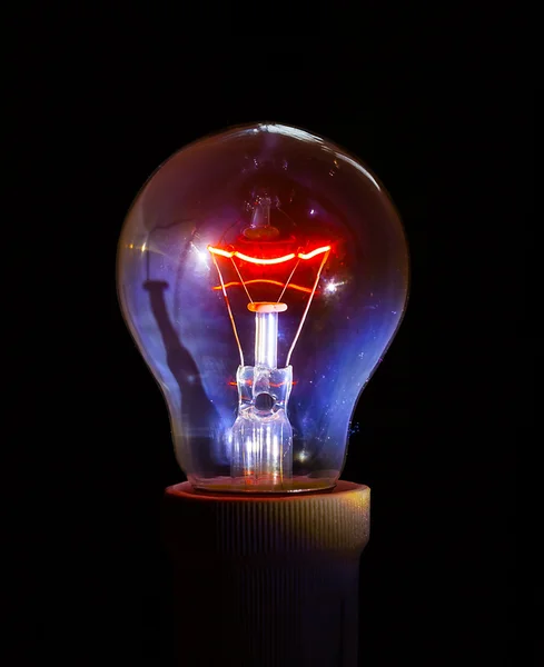 Glowing light bulb with detailed filament and inner glass body.