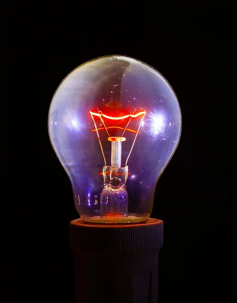 Glowing light bulb with detailed filament and inner glass body.