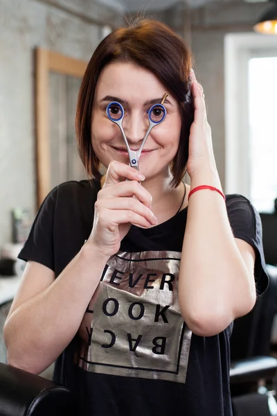 Woman barber with scissors at work