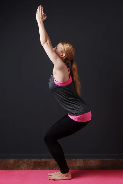 Young blonde woman doing yoga exercise