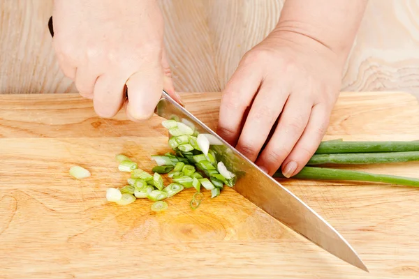 Chef cuts green onion
