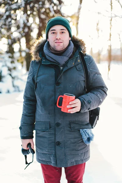 Handsome young man standing in winter forest