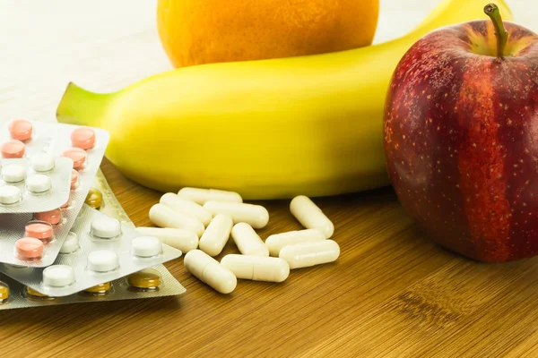 Vitamin pills and various fresh fruits