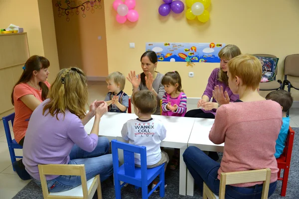 KALININGRAD, RUSSIA - APRIL 17, 2014: The general game of children with parents at a table. Studio of creative development