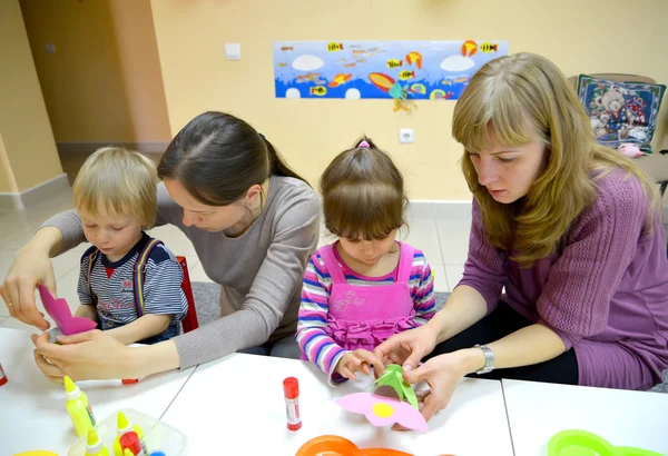 KALININGRAD, RUSSIA - APRIL 17, 2014: Children and mothers together do applications in studio of creative development