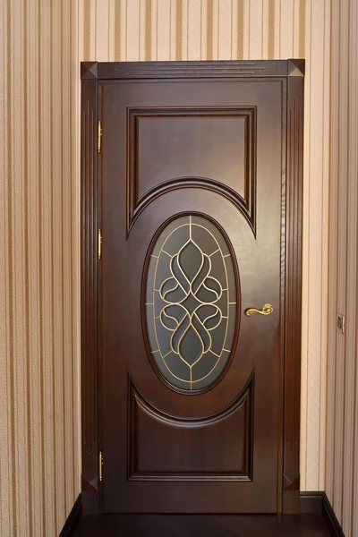 Wooden brown door with a stained-glass window in the room