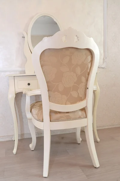 Dressing table and white chair in a hotel room 