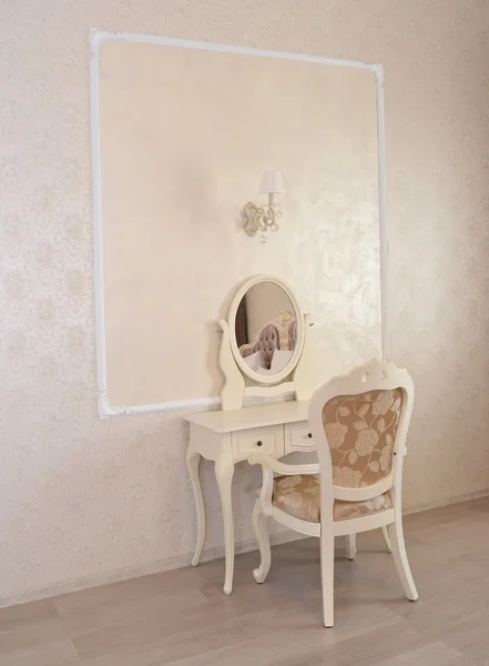 Dressing table and white chair in a hotel room 