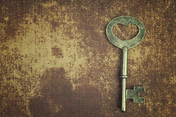 Old vintage key on shabby chic surface
